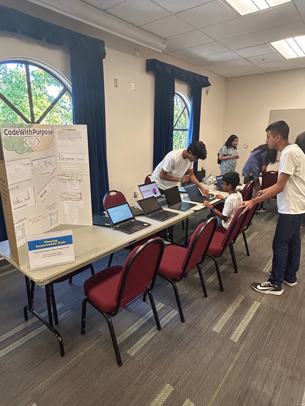 Volunteer helping a student at their laptop